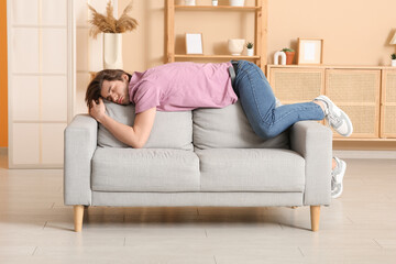 Weary young man sleeping on sofa at home