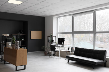 Interior of modern office with programmer's desk and couch