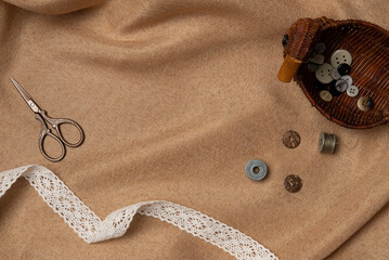 Mockup in vintage style with scissors and buttons on a fabric background from above. Copy space