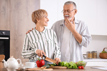 Mature deaf mute couple cooking in kitchen