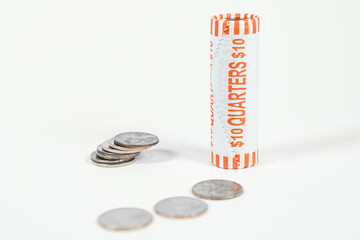 A roll of quarters with a white background and loose coins