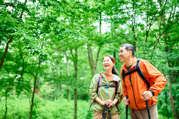  初夏の山でトレッキングするシニア夫婦