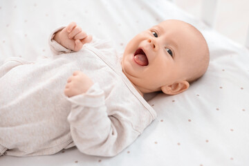 Cute little baby lying in crib at home