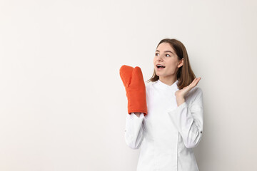 Professional chef with oven glove on light background. Space for text