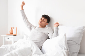 Young man stretching in bedroom