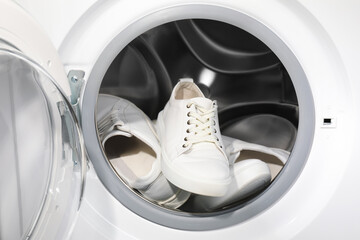 Stylish clean sneakers inside modern washing machine