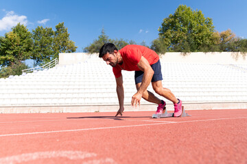 Fototapeta premium Stadium, man running and start block of athlete on a runner and arena track for sprint