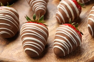 Delicious chocolate covered strawberries on wooden board, closeup
