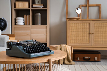 Vintage typewriter on table in living room, closeup