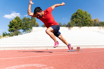Fototapeta premium Stadium, man running and start block of athlete on a runner and arena track for sprint