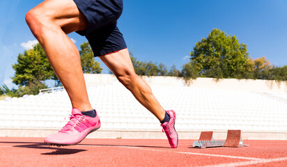 Stadium, man running and start block of athlete on a runner and arena track for sprint