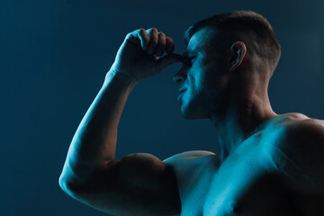 Muscular model sports young man on dark background. Fashion portrait of strong brutal guy. Male...