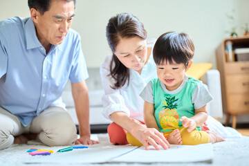 2歳の孫とお絵描きをするシニア夫婦