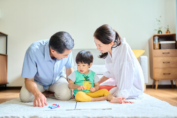Fototapeta premium 2歳の孫とお絵描きをするシニア夫婦