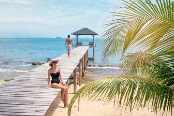 Luxury lifestyle and vacation. Tanning and sunbathing on the beach. Young womanand man in swimwear...