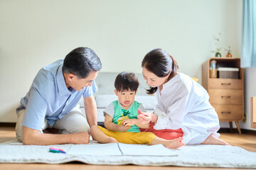 2歳の孫とお絵描きをするシニア夫婦