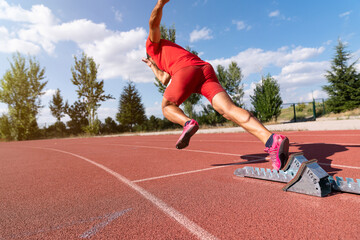 Stadium, man running and start block of athlete on a runner and arena track for sprint