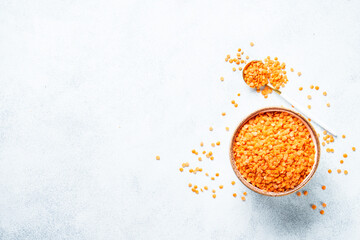 Red lentils in craft bowl on white background. Flat lay.