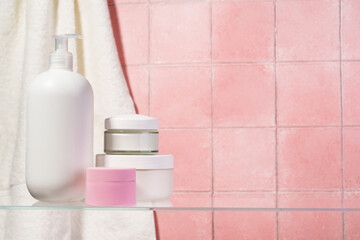 Bathroom with Cosmetic products at glass shelf.