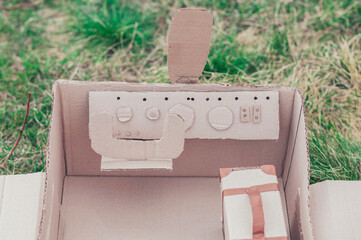 Toy cardboard plane in the field. Focus on the steering wheel