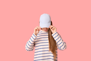 Young woman in stylish blue cap on pink background