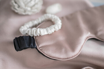 Fototapeta premium Beige silk sleeping mask and white silk scrunchy. Accessories for girls.