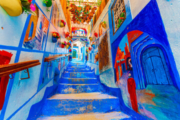 Chefchaouen, Morocco: Blue narow stairs with colourful walls and flowerpots into old walled city,...