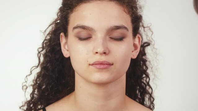 Eye shadow makeup to the upper eyelid, close-up. Makeup artist applies a bright eye shadow with a make-up brush.Tutorial master class of professional makeup, smoky eyes 