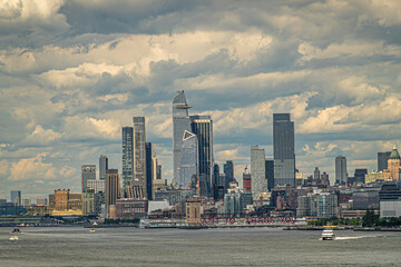 New York, NY, USA - August 1, 2023: 30 Hudson Yards and other skyskrapers under blue cloudscape. I want to thank you message on Pier 40. Small brown tower Holland Tunnel ventilation shaft 2.