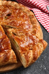 Cut delicious homemade pie on black table, closeup