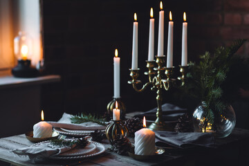 Elegant decor for Christmas family dinner. Center piece with burning candles, vintage chandelier....