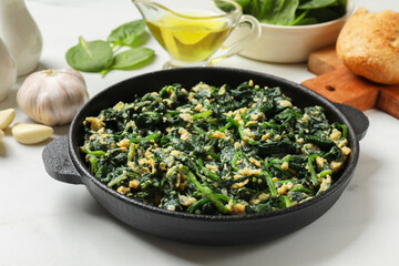 Tasty spinach dip with eggs in dish served on white table, closeup