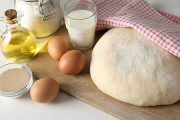 Raw dough and ingredients on white wooden table