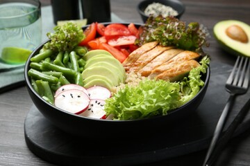Healthy meal. Tasty products in bowl on black wooden table