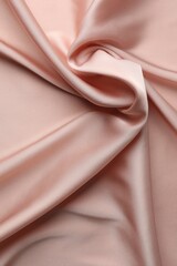 Crumpled pink silk fabric as background, top view