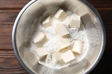 Making shortcrust pastry. Flour and butter in bowl on wooden table, top view