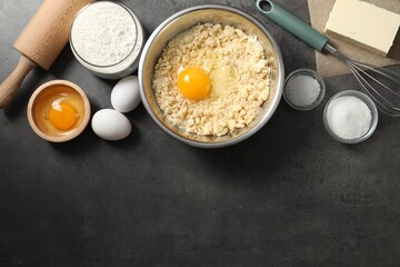 Making shortcrust pastry. Different ingredients for dough, rolling pin and whisk on grey table, flat lay. Space for text