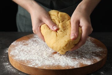 Making shortcrust pastry. Woman kneading dough at table, closeup