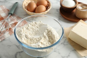 Making shortcrust pastry. Different ingredients for dough and whisk on white marble table