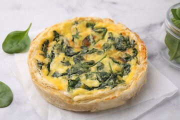 Delicious pie with spinach on white marble table, closeup