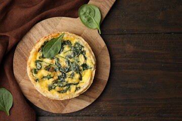 Delicious pie with spinach on wooden table, top view. Space for text