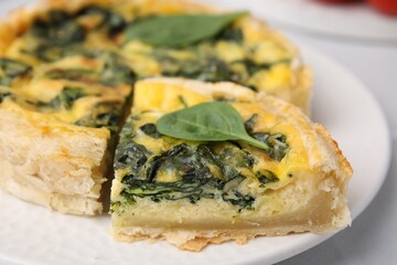 Delicious pie with spinach on white table, closeup
