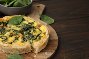 Delicious pie with spinach on wooden table, closeup