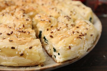Delicious puff pastry with spinach on table, closeup