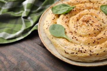 Delicious puff pastry with spinach on wooden table, closeup