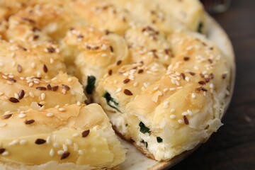 Delicious puff pastry with spinach on table, closeup