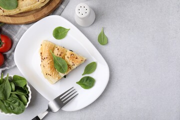 Piece of delicious puff pastry with spinach on light table, flat lay. Space for text