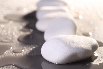 White spa stones with water drops on grey background, closeup