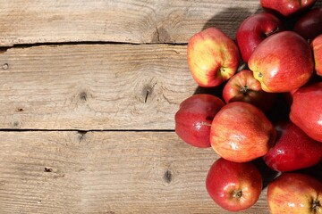 Many fresh apples with water drops on wooden table, top view. Space for text