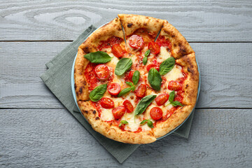 Delicious Margherita pizza on gray wooden table, top view